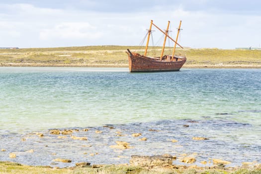 An old whaler wreck in Whalebone Cove off Stanley in the Falkland Islands. Stanley in the background