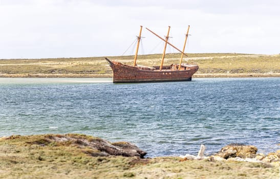An old whaler wreck in Whalebone Cove off Stanley in the Falkland Islands. Stanley in the background