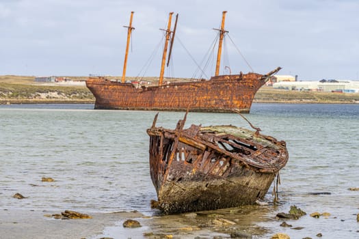 An old whaler wreck in Whalebone Cove off Stanley in the Falkland Islands. Stanley in the background