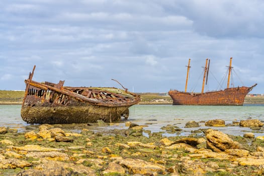 An old whaler wreck in Whalebone Cove off Stanley in the Falkland Islands. Stanley in the background