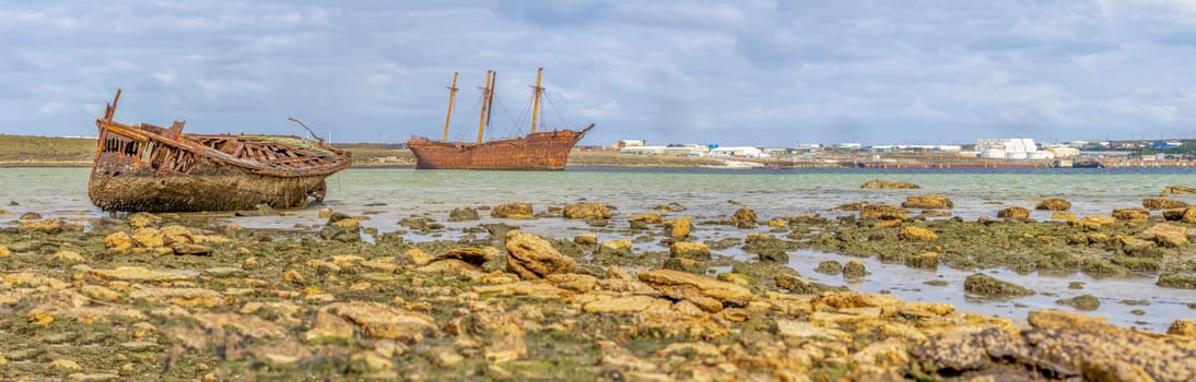 An old whaler wreck in Whalebone Cove off Stanley in the Falkland Islands. Stanley in the background