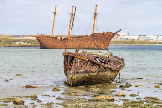 An old whaler wreck in Whalebone Cove off Stanley in the Falkland Islands. Stanley in the background