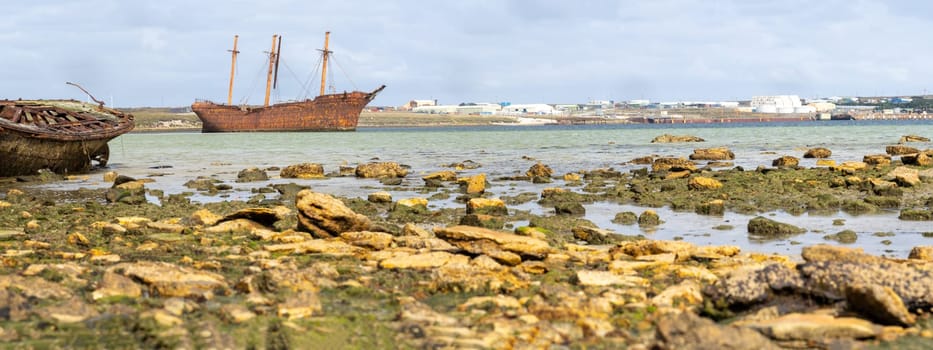 An old whaler wreck in Whalebone Cove off Stanley in the Falkland Islands. Stanley in the background