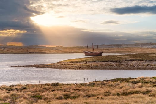 An old whaler wreck in Whalebone Cove off Stanley in the Falkland Islands. Stanley in the background