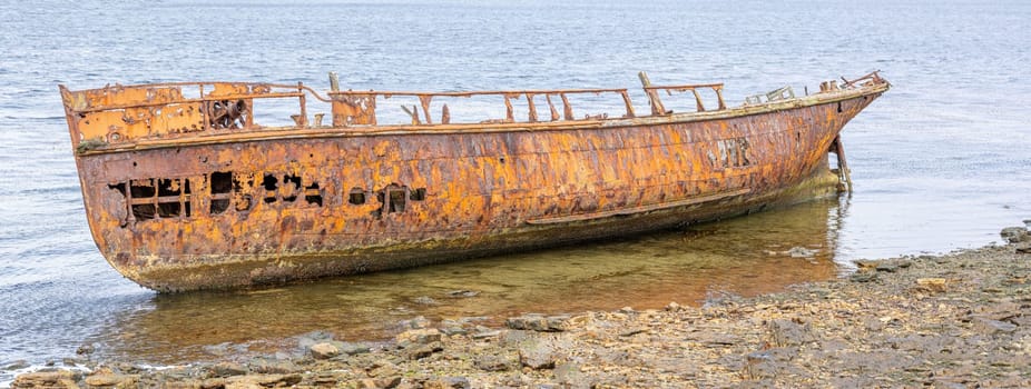 An old whaler wreck in Whalebone Cove off Stanley in the Falkland Islands. Stanley in the background