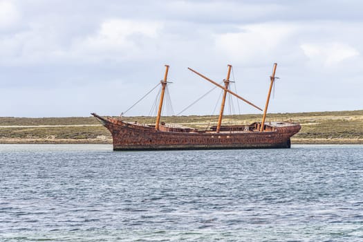 An old whaler wreck in Whalebone Cove off Stanley in the Falkland Islands. Stanley in the background