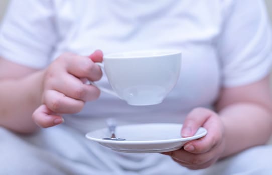 Women holding a cup of coffee and drinking coffee on blurred background