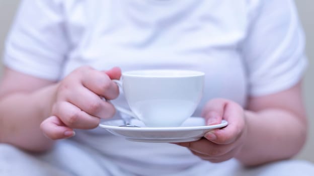 Women holding a cup of coffee and drinking coffee on blurred background