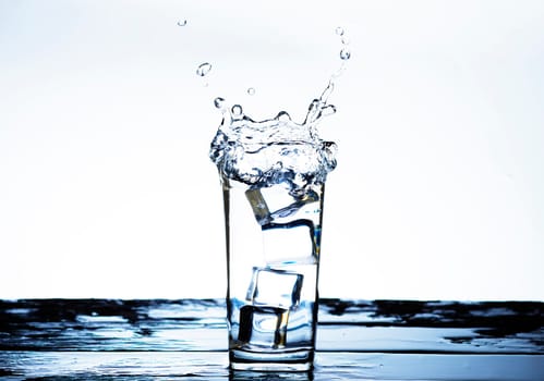 The image of pouring drinking water, into a glass, that makes one feel refreshed on blurred white background, Splashing water, Sparkling water