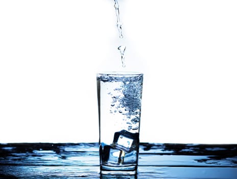 The image of pouring drinking water, into a glass, that makes one feel refreshed on blurred white background, Splashing water, Sparkling water
