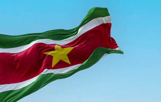 Suriname national flag waving in the wind on a clear day. 5 horizontal bands: green, white, red, white, green, yellow star in the center. 3D illustration render. Fluttering textile