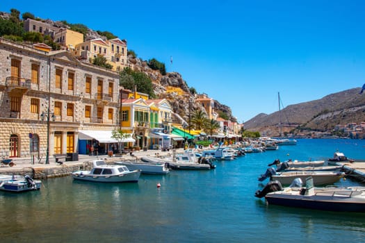 SYMI, Greece - Jun 03, 2021. The harbour of Symi town with the districts of Chorio and Gialos is one of the most beautiful and romantic in the whole Aegean. Colourful mansions stretch up the steep slopes.