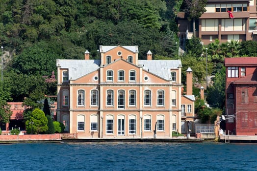 View from Bosphorus strait of the green mountains of the Asian side, with traditional houses and dense trees in a summer day, Istanbul, Turkey