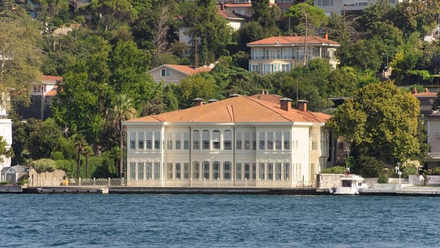 View from Bosphorus strait of the green mountains of the Asian side, with traditional houses and dense trees in a summer day, Istanbul, Turkey