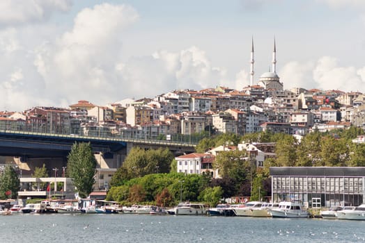 View of the Golden Horn coast with docked ferry boats and Ataturk Bridge in the far end, Istanbul, Turkey