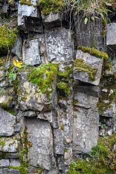 High rocky stone wall with green moss