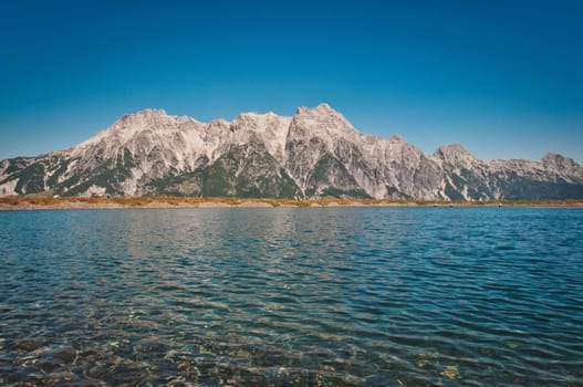 Asitz mountain in the background of the pure and calm lake, Austria