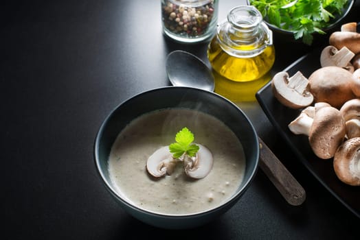 Hot Soup with fresh mushrooms on black background.