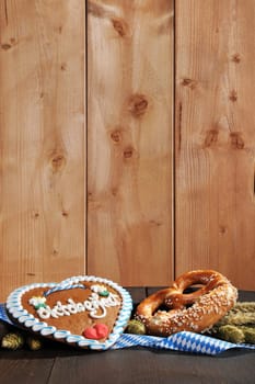 Bavarian Oktoberfest breze with gingerbread heart,hofen and wheat on old beer barrel