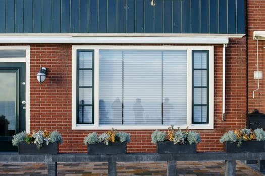 A pretty little terraced house with flower boxes in front of the entrance.