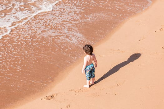 Young boy child on beach ocean water  sands new explore adventure overhead photo.