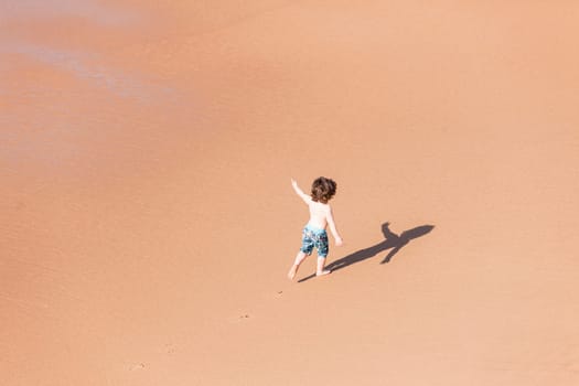 Young boy child on beach ocean water  sands new explore adventure overhead photo.