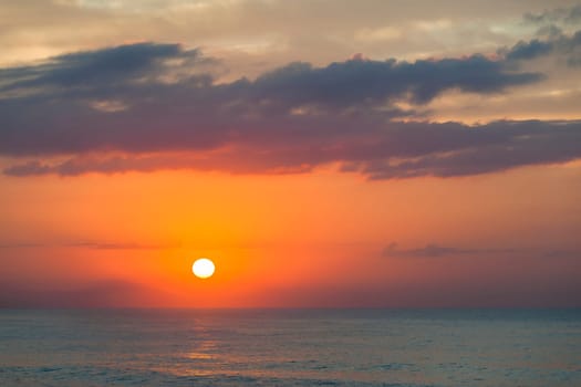 Ocean waters early dawn sunrise on the horizon.