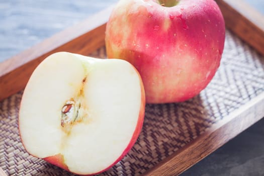 Red apple on wooden tray, stock photo