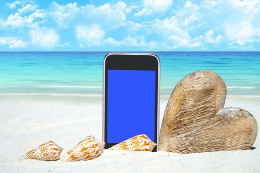 Smartphone,heart of wood and shells on the beach