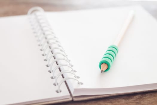 Pencil on open blank notebook, stock photo