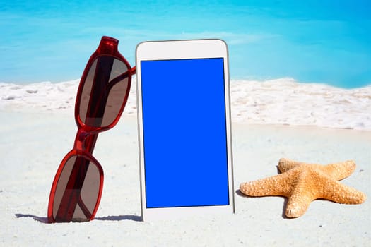 White smartphone,sunglasses and starfish on the beach