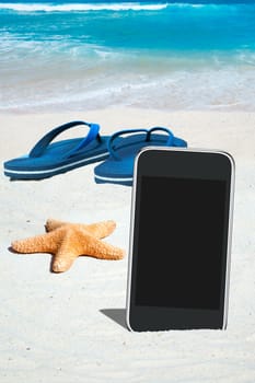 Smartphone,flip flops and starfish on the beach