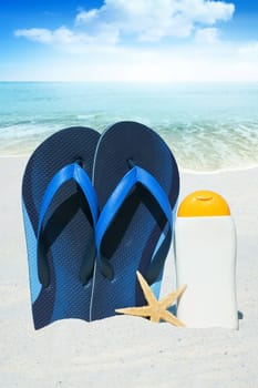 Flip flops,sunmilk and starfish on the beach
