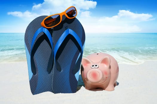 Pink piggy bank,flips flops and sunglasses on the beach