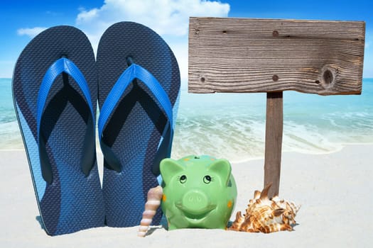 Piggy bank,flips flops and empty wooden sign on the beach