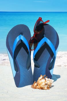 With flip flops and sunglasses on the beach