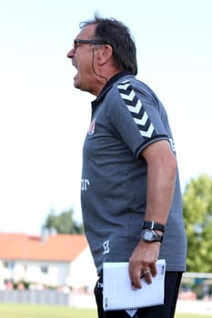 Vulka with notepad on the sidelines: Coach Ewald Lienen (Saint Pauli) at the test match Friedrichshafen: SC Freiburg - FC St. Pauli
