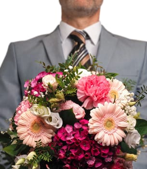 Man in an elegant suit hands over a colorful bouquet of flowers, Wedding or Valtentines Day or Mothersday concept, white background