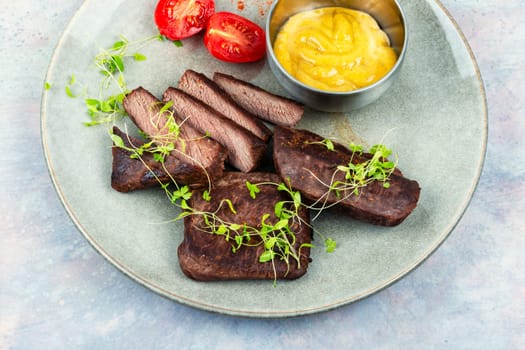 Delicious grilled ostrich meat steaks with microgreens. African cuisine.