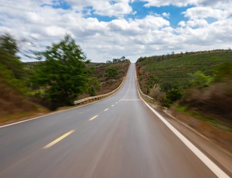 Countryside road and clousy sky. Photo taken in motion