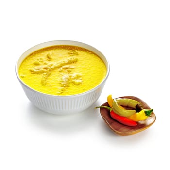 Tripe soup in a white bowl and hot peppers