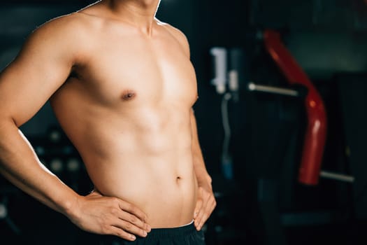 A muscular man in his underwear, standing with a confident and sexy attitude, showcases his toned body and bicep muscles for a fitness advertisement. Healthy fitness Lifestyle with copy space