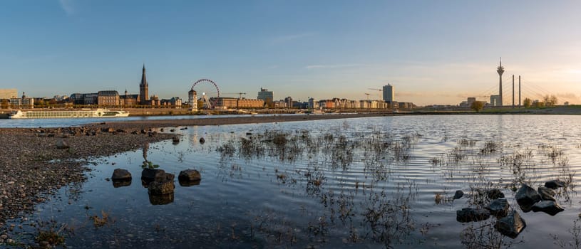 DUSSELDORF, GERMANY - NOVEMBER 24, 2022: Sunset on the Rhine river with the cityscape of Dusseldorf in the background on November 24, 2022 in Germany