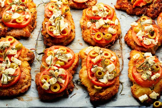 Chicken chops with tomato, olives and cheese. Rustic style