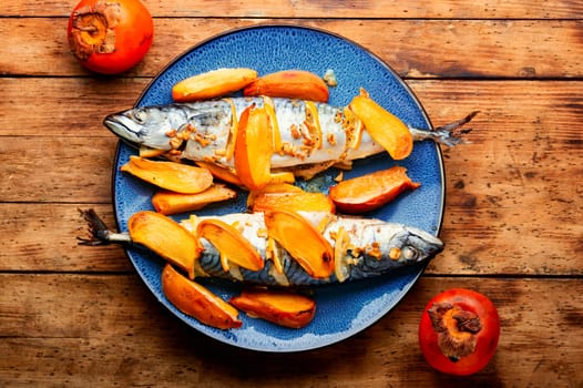 Fish cooked in persimmon fruit marinade on a concrete kitchen table. Whole baked fish, mackerel. Top view.