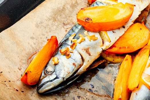 Fish cooked in persimmon fruit marinade on a concrete kitchen table. Whole baked fish, mackerel. Top view.