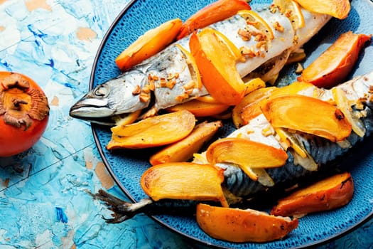 Fish cooked in persimmon fruit marinade on a concrete kitchen table. Whole baked fish, mackerel. Top view.