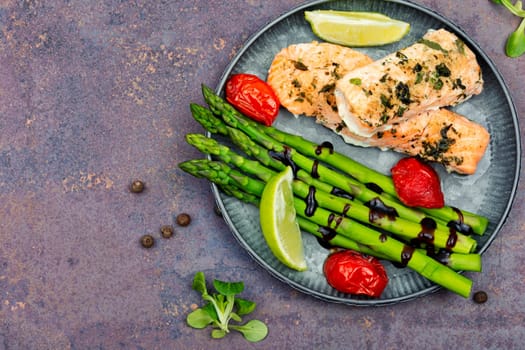 Tasty dish of trout, asparagus and tomato. Baked salmon. Space for text.