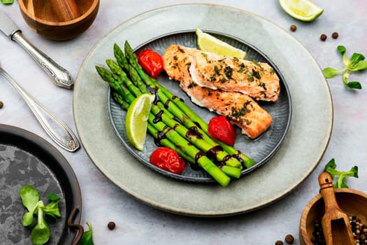 Tasty dish of trout, asparagus and tomato. Baked salmon. Space for text.