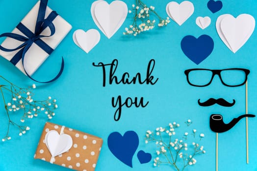 Flat Lay With English Text Thank You. Blue Accessories Like Presents, Hearts, Flowers And Male Decoration Like Mustache. Flat Lay With Turquoise Paper Background.